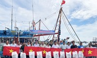 Coast Guards stand side by side with fishermen