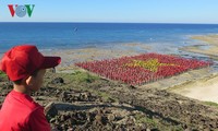 Record des chanteurs de l’hymne nationale formant le drapeau national sur la plage