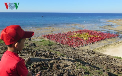 Record des chanteurs de l’hymne nationale formant le drapeau national sur la plage