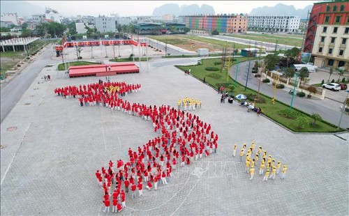 500 élèves forment la carte du Vietnam et le drapeau national au bord de la baie de Bai Tu Long - ảnh 1
