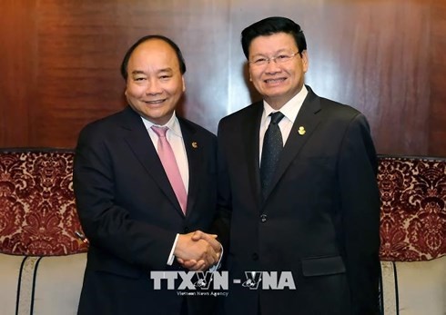 PM Nguyen Xuan Phuc melakukan pembicaraan dengan PM Thailand, Prayuth Chan-ocha dan PM Laos, Thongloun Sisoulith - ảnh 1