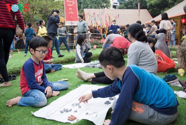 Warga Kota Hanoi membawa anak ke tempat meminta aksara awal tahun di Danau Van - ảnh 17